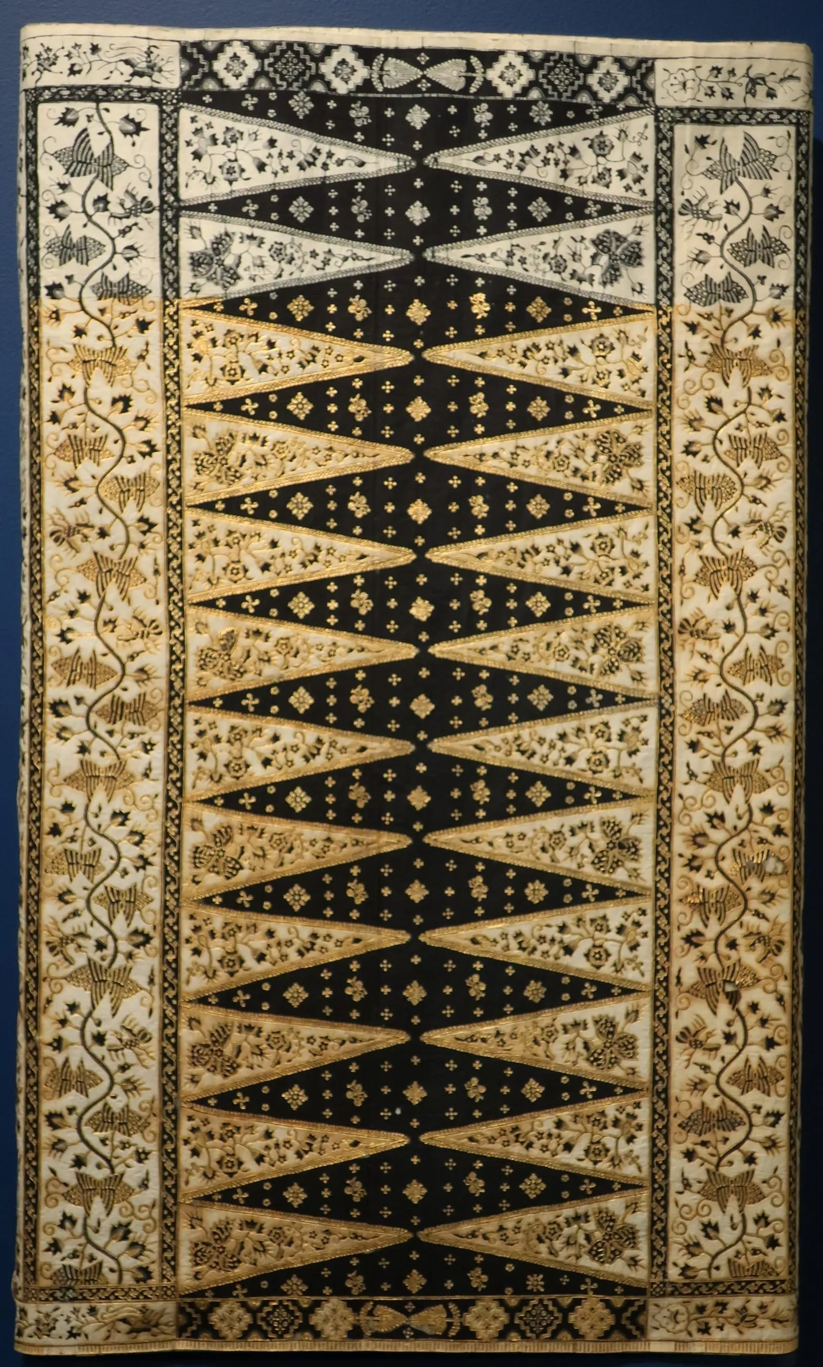 Kain batik bermotif tumpal hitam dan krem